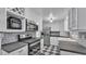 Kitchen with stainless steel appliances, checkerboard floors, and white cabinetry at 516 Windsor St, Lakeland, FL 33803