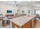 Open kitchen and living area with a large kitchen island, stainless steel appliances, and comfortable seating at 5393 Se 129Th Ln, Belleview, FL 34420