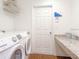 Clean laundry room with updated appliances, a shelf, countertop, and door to the rest of the house at 5393 Se 129Th Ln, Belleview, FL 34420