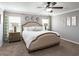 Comfortable bedroom featuring a ceiling fan, side tables, and lots of natural light from the windows at 5393 Se 129Th Ln, Belleview, FL 34420