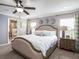 Relaxing bedroom featuring a ceiling fan, side tables, a well-made bed, and a door to the bathroom at 5393 Se 129Th Ln, Belleview, FL 34420