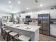 Beautiful kitchen featuring a large center island with seating, stainless steel appliances, and stylish white cabinetry at 5424 Se 127Th Ln, Belleview, FL 34420