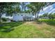 Expansive backyard with lush green lawn and mature trees surrounding the home at 5425 Charlin Ave, Lakeland, FL 33810