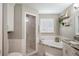 Elegant bathroom with a soaking tub, a separate shower, and a window with plantation shutters for natural light at 5425 Charlin Ave, Lakeland, FL 33810