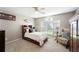 Comfortable bedroom features a built-in headboard, neutral colors, a ceiling fan, and a chair by a large window at 5425 Charlin Ave, Lakeland, FL 33810