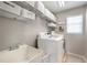Functional laundry room with a washing machine, dryer, sink, storage shelves, and a window for natural light at 5425 Charlin Ave, Lakeland, FL 33810
