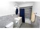 This bathroom features gray tile walls, shower/tub combo, vanity sink, medicine cabinet, and updated fixtures at 5425 Lewellyn Rd, Lakeland, FL 33810