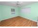 This bedroom features a ceiling fan, hardwood floors, windows for natural light, and neutral paint at 5425 Lewellyn Rd, Lakeland, FL 33810