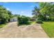 Large driveway with ample parking space, complemented by lush greenery and mature trees at 5425 Lewellyn Rd, Lakeland, FL 33810