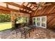 An open air patio has a stone floor, stone walls and wooden beamed roof with ceiling fan at 5425 Lewellyn Rd, Lakeland, FL 33810