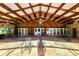 An open air patio has a stone floor, stone walls and wooden beamed roof with ceiling fans at 5425 Lewellyn Rd, Lakeland, FL 33810