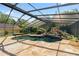 A screened in pool with a unique rock feature and solar panels on the adjacent building at 5425 Lewellyn Rd, Lakeland, FL 33810