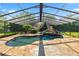 A beautiful in-ground pool has a waterfall feature, enclosed screen and a stone deck at 5425 Lewellyn Rd, Lakeland, FL 33810