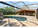 The screened in pool sits next to a patio area and offers views of the surrounding greenery at 5425 Lewellyn Rd, Lakeland, FL 33810
