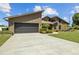Stunning home with a two-car garage, beautiful landscaping, and mature trees surrounding the property at 5519 Club W Hl, Lakeland, FL 33812