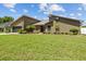 Well-maintained single-Gathering home with a lush green lawn, mature trees, and an attached garage at 5519 Club W Hl, Lakeland, FL 33812