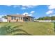 The sprawling backyard features a well-maintained lawn, enclosed patio, and white fencing at 555 Heather Glen Dr, Winter Haven, FL 33884