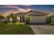 Charming single-story home with a well-manicured lawn, tropical landscaping, and an attached two-car garage at 555 Heather Glen Dr, Winter Haven, FL 33884
