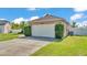 A large two car garage with a paved driveway and freshly cut grass in front of a well-maintained home at 555 Heather Glen Dr, Winter Haven, FL 33884