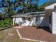 Rear view of the home showing a brick patio, a garden, and well-maintained landscaping at 5624 Laurel Oak Dr, Lakeland, FL 33811