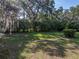 Expansive lawn area surrounded by greenery and shady trees offers plenty of outdoor space at 5624 Laurel Oak Dr, Lakeland, FL 33811