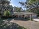 Inviting single-Gathering home featuring a covered porch with rocking chairs, complemented by a manicured lawn and mature trees at 5624 Laurel Oak Dr, Lakeland, FL 33811