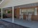 Close-up view of a covered front porch featuring brick columns and a pair of classic rocking chairs for relaxing outdoors at 5624 Laurel Oak Dr, Lakeland, FL 33811