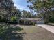 Welcoming single-story home with a lovely front lawn, a covered porch with rocking chairs, and mature shade trees at 5624 Laurel Oak Dr, Lakeland, FL 33811