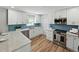 Bright kitchen features white cabinetry, blue backsplash, stainless steel appliances and granite countertops at 5624 Laurel Oak Dr, Lakeland, FL 33811