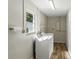 Bright laundry room with washer, dryer, wood-look floors, and a window bringing in natural light at 5624 Laurel Oak Dr, Lakeland, FL 33811