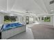 Large sunroom with a built-in spa, neutral carpeting, and large windows showcasing the serene landscape at 5624 Laurel Oak Dr, Lakeland, FL 33811