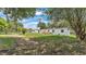 This backyard features a deck with wooden railing and a well-manicured lawn with mature trees at 5751 Cherry Tree Dr, Lakeland, FL 33811