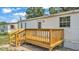 A wooden deck sits in the backyard of this home with stairs that lead down to the lawn at 5751 Cherry Tree Dr, Lakeland, FL 33811