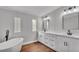 Bright bathroom with a soaking tub, modern fixtures, and double sinks at 5751 Cherry Tree Dr, Lakeland, FL 33811