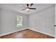 Bedroom featuring wood-look floors, ceiling fan, and a window overlooking the yard at 5751 Cherry Tree Dr, Lakeland, FL 33811