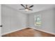 Bedroom featuring wood-look floors, ceiling fan, and a window overlooking the yard at 5751 Cherry Tree Dr, Lakeland, FL 33811