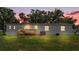 The backyard of this home has a wooden deck, green lawn, and mature trees at 5751 Cherry Tree Dr, Lakeland, FL 33811