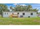 This is the back of the home, showing a deck, lawn, and other backyard features at 5751 Cherry Tree Dr, Lakeland, FL 33811