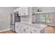 Stylish kitchen featuring white cabinetry, quartz countertops, and stainless steel appliances adjacent to the living area at 5751 Cherry Tree Dr, Lakeland, FL 33811
