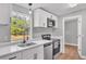 Updated kitchen showcasing white cabinets, stainless steel appliances, and a view of the backyard through the window above the sink at 5751 Cherry Tree Dr, Lakeland, FL 33811