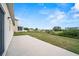 Long patio with a grassy backyard and neighborhood views behind the home at 5793 Dornich Dr, Auburndale, FL 33823