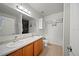 Bathroom with dual sinks, wood cabinets, and tiled floors and a separate toilet and shower at 5793 Dornich Dr, Auburndale, FL 33823