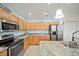 Well-lit kitchen featuring stainless steel appliances, light wood cabinets and granite countertops at 5793 Dornich Dr, Auburndale, FL 33823