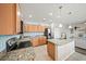 Open kitchen featuring stainless steel appliances, light wood cabinets, granite countertops and island at 5793 Dornich Dr, Auburndale, FL 33823