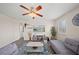 Cozy living room featuring a comfortable gray sofa, ceiling fan, and a mounted television at 5793 Dornich Dr, Auburndale, FL 33823