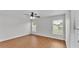 Bright bedroom featuring wood-look flooring, a ceiling fan, and natural light from two windows at 601 Pintail Cir, Auburndale, FL 33823