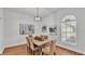 Bright dining room boasts wood floors, contemporary light fixture, and seamless access to other living spaces at 601 Pintail Cir, Auburndale, FL 33823