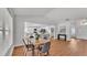 Bright dining room open to kitchen with modern table and wood-look flooring at 601 Pintail Cir, Auburndale, FL 33823
