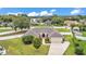 Aerial view of home with well-manicured lawn, mature trees, and attached two-car garage at 601 Pintail Cir, Auburndale, FL 33823