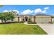 Charming single-story home features a well-manicured lawn, lush landscaping, and an attached two-car garage at 601 Pintail Cir, Auburndale, FL 33823